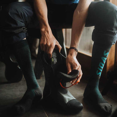 Narciarz wkłada wkładki Sidas 3Feet Eco Warm do butów